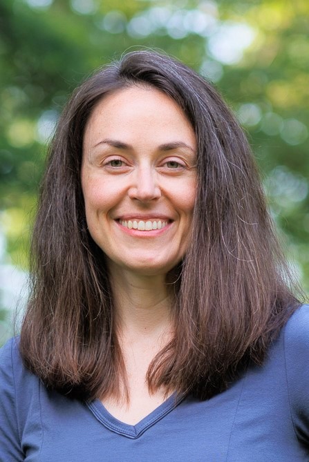 Lisa Gerstner smiles in a blue shirt with trees in the background.
